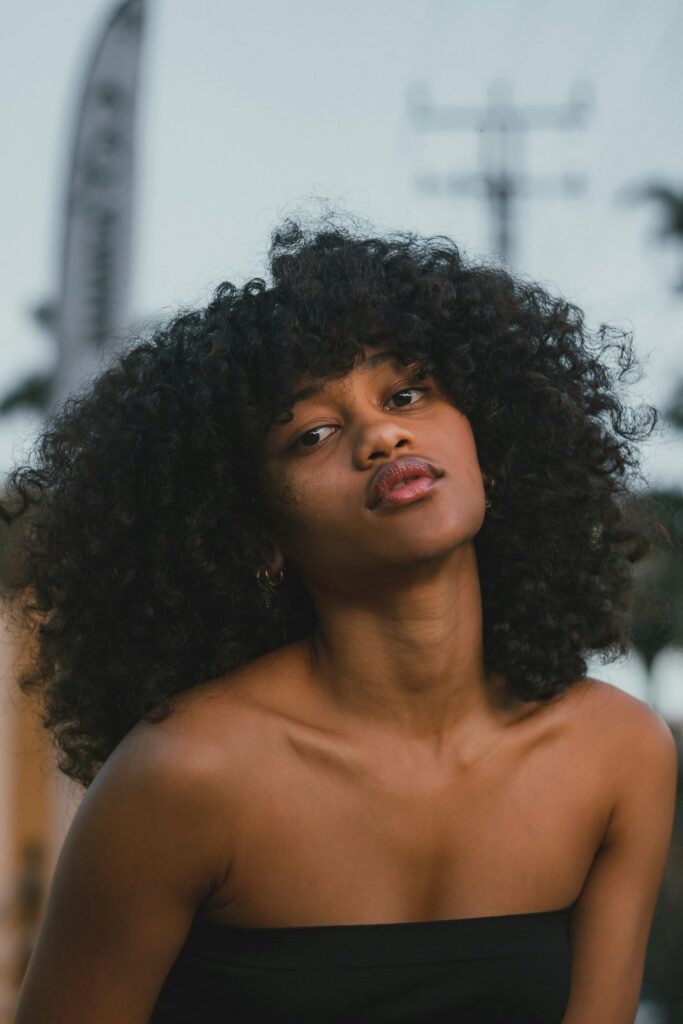 Smiling woman with curly hair and glowing skin